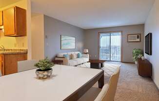 a living room with a white table and chairs and a sliding glass door leading to a balcony at France, Fargo, ND