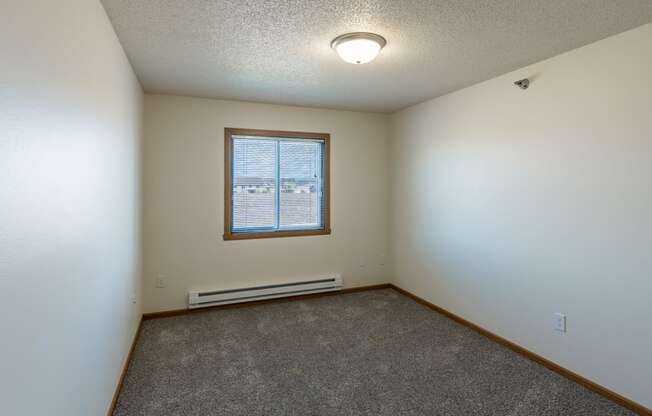 Fargo, ND Parkside Apartments. A bedroom with a window and carpet