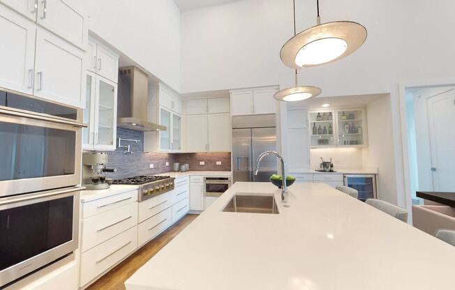a large kitchen with a white counter top and a sink