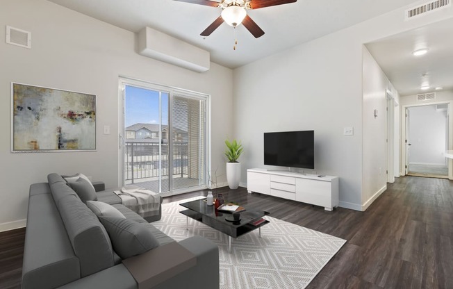 a living room with a ceiling fan and a large window