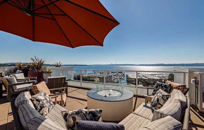 Vela Apartments seating area with a fire pit and a view of the water
