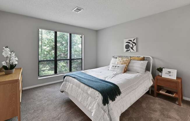 a bedroom with a bed and a large window