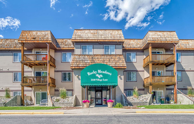 a large apartment building with a green sign in front of it