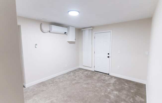 an empty living room with white walls and a white door