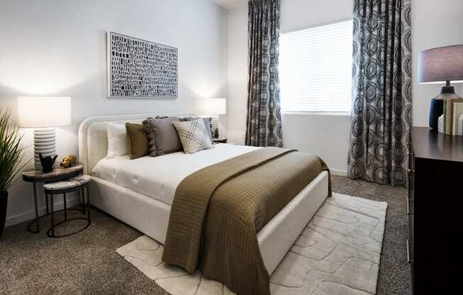 a bedroom with a bed and a window with curtains at Aura Vegas Apartments, Las Vegas, 89103
