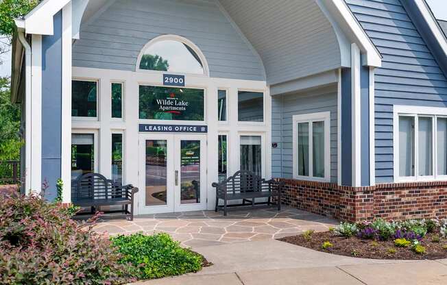 the front of a building with two benches and a porch