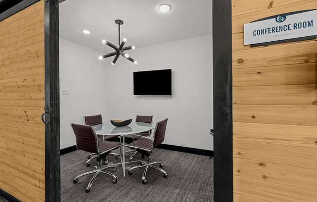 A conference room with a table and chairs and a sign on the wall.