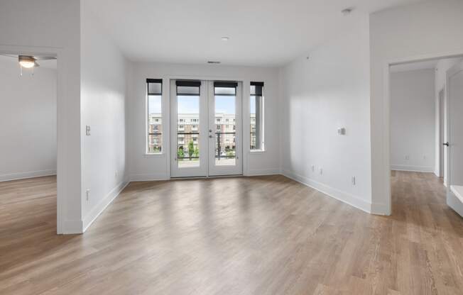 a living room with white walls and a door to a balcony