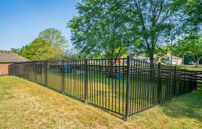 a wrought iron fence in front of a yard with a playground at Traditions at Slate Ridge, Reynoldsburg Ohio