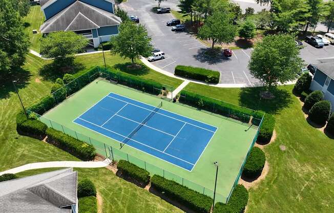 an aerial view of a tennis court in a parking lot