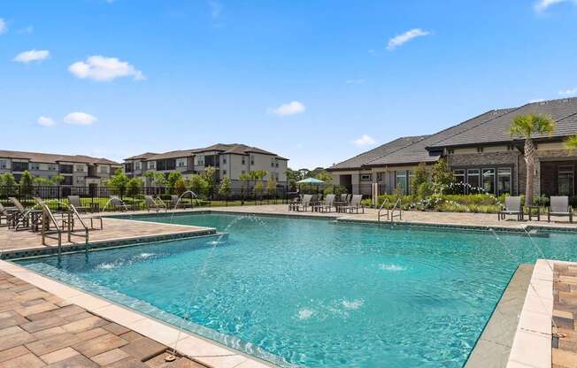 A large swimming pool with a fountain in the middle and chairs around it.