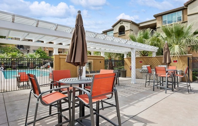 a patio with tables and chairs and a pool