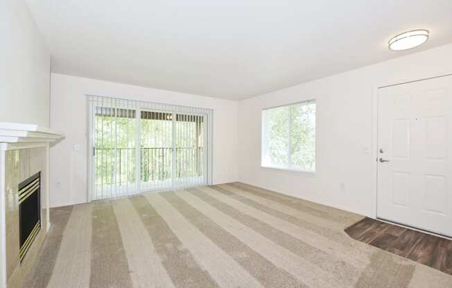 an empty living room with a fireplace and a window