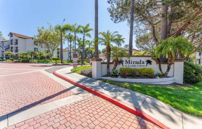 the entrance to mira la quinta apartments with palm trees