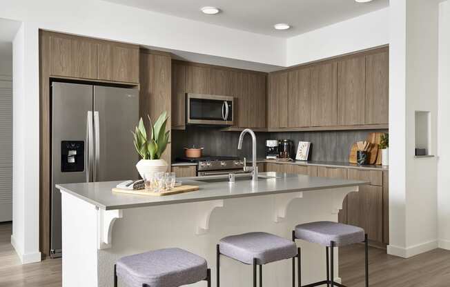 a kitchen with a large island with three stools