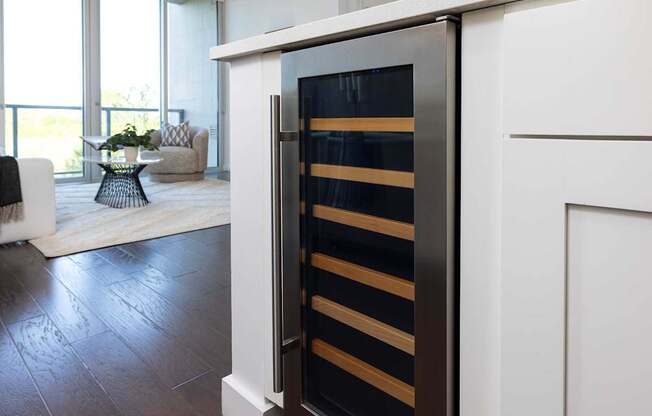 A modern kitchen with a white cabinet and a black and gold fridge.