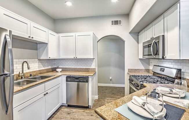 A kitchen with white cabinets and stainless steel appliances.