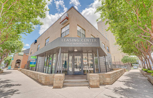 Leasing center exterior with stone base and entrance at Vue Live Oak Apartments, Dallas