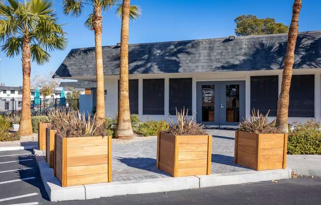 a building with a gray roof and palm trees in front of it