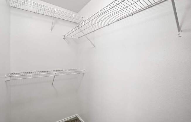 A white wall with a metal shelf on it.