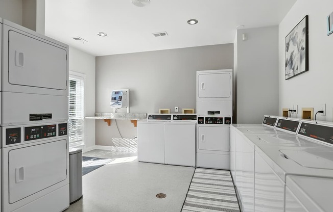 A row of white washing machines in a laundry room.