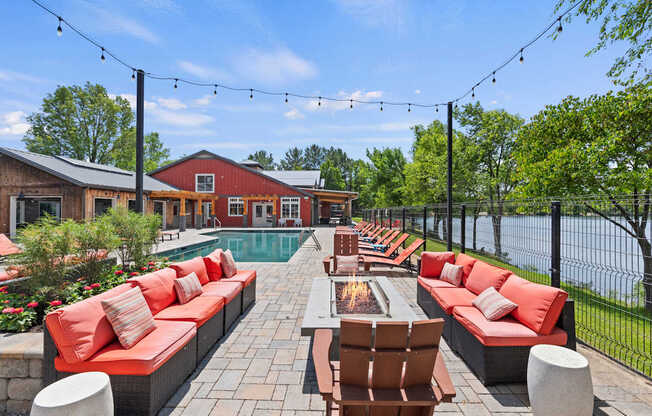A patio with red couches and a fire pit.