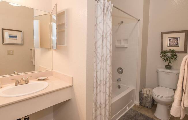 A white bathroom with a sink, toilet, and shower at Autumn Oaks Apartments, Roseville, CA, 95678