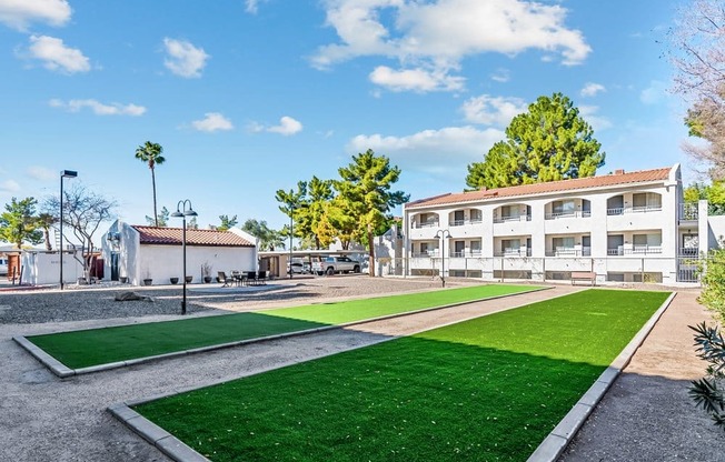 A sunny day at a park with a building in the background.