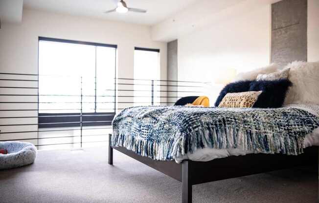 A bedroom with a bed, pillows, and a blanket.