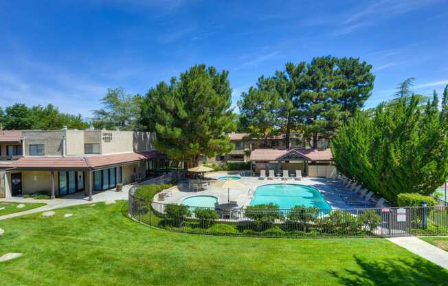 Outdoor Swimming Pool and Spa with Grass, Trees and Apartment Exteriors