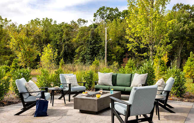 A set of outdoor furniture is arranged on a stone patio.