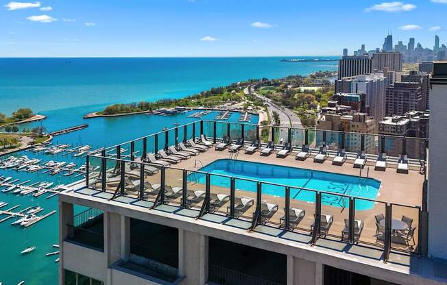 A marina with boats and a pool with chairs.
