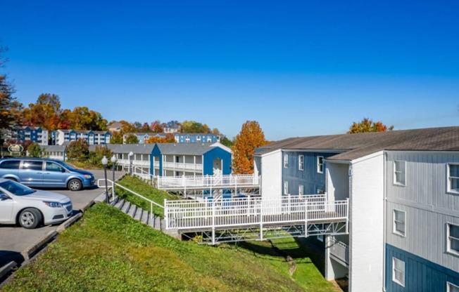 a row of houses with a deck and cars parked in a parking lot