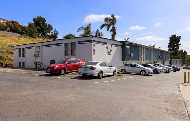 A parking lot with cars and a building in the background.