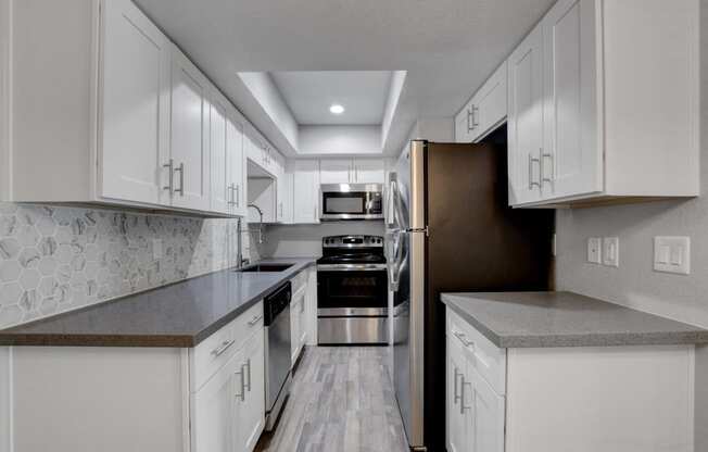 a kitchen with white cabinets and stainless steel appliances