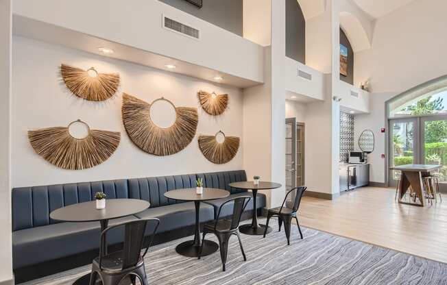 a lobby with tables and chairs and a large window