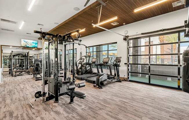 A gym with a variety of equipment including treadmills, weights, and exercise machines.