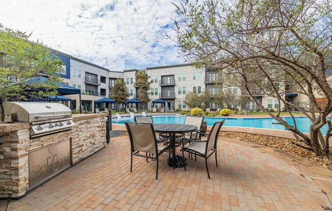 a patio with a table and chairs next to a swimming pool