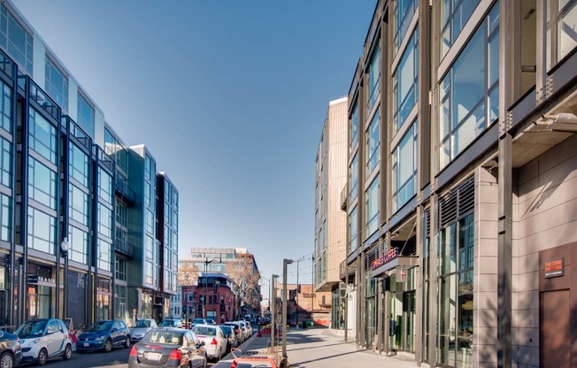 a city street with cars parked on the side of the road and tall buildings on either side at The Shay, Washington, DC 20001