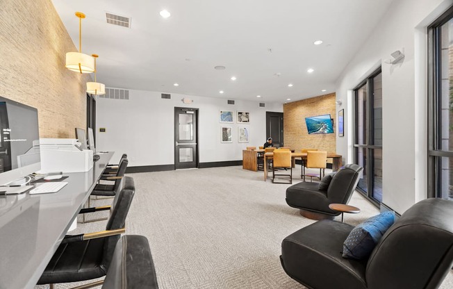 A waiting area with black leather chairs and a white reception desk.