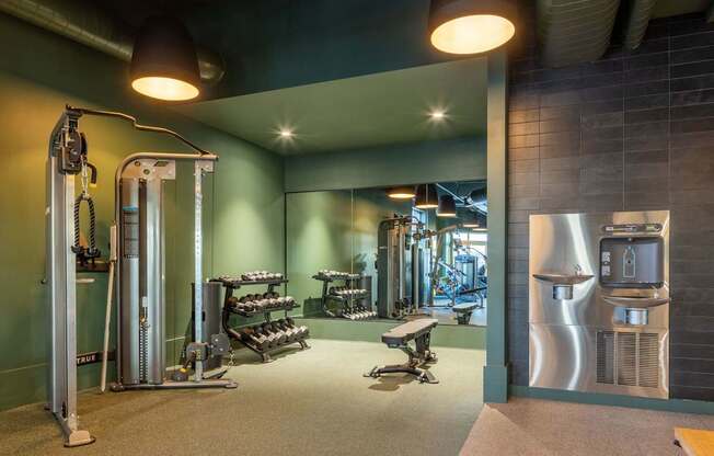 A gym with a variety of equipment including a squat rack, bench, and weights.