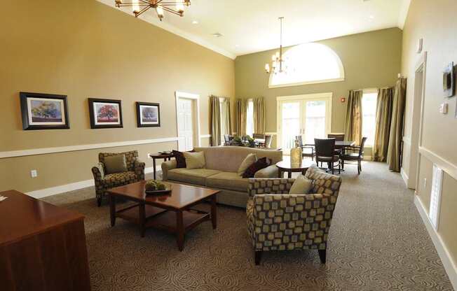 A living room with a couch, chairs, and pictures on the wall.