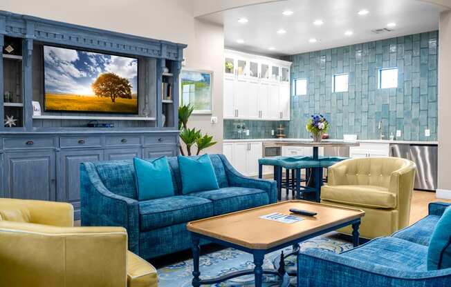 a living room with blue couches and chairs and a tv