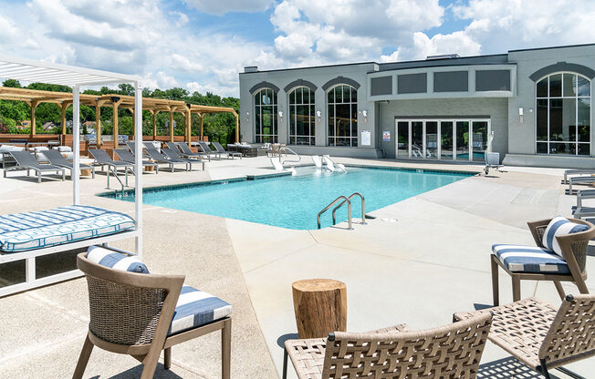 a swimming pool with chairs and a building in the background at The Heights Apartments, Cincinnati, OH, 45220