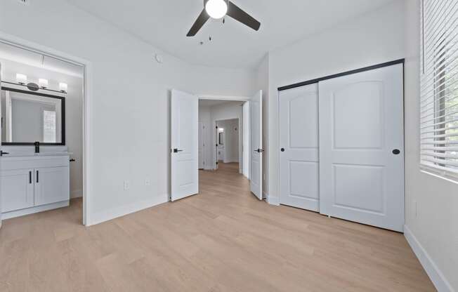 a bedroom with two closets and a ceiling fan