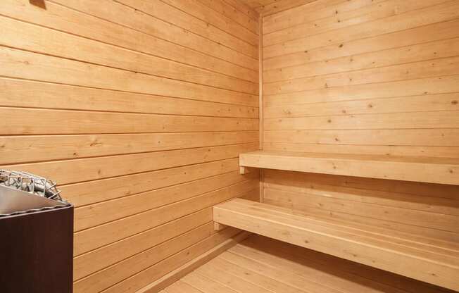 A wooden sauna with benches and a table.
