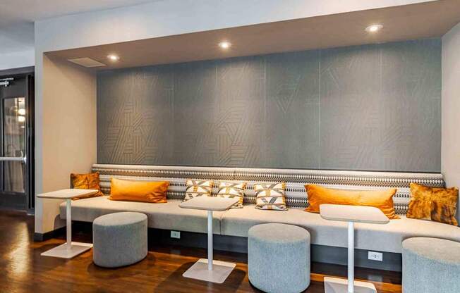 A modern living room with a grey sofa and a grey and white bench.