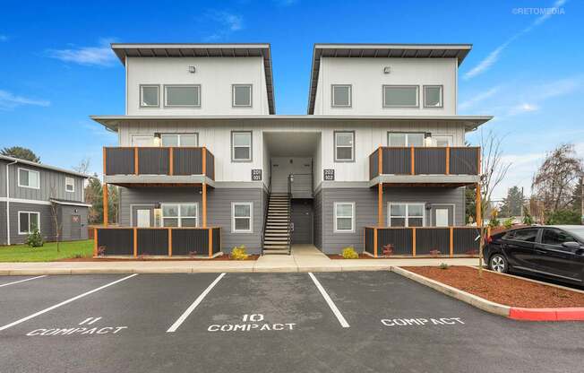 A two-story building with a parking lot in front.