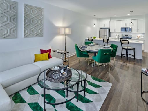 a living room with a couch and a table and a kitchen at The Encore at Ingram Manor, Pikesville, 21208