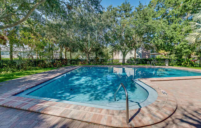 a swimming pool with trees in the background